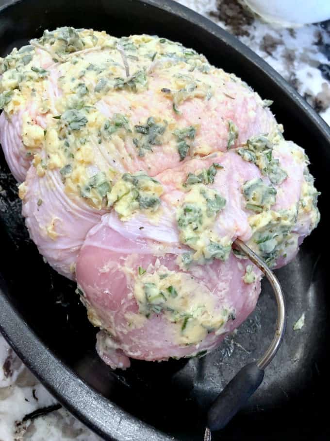 Herbed Buttered Turkey Breast in a roasting pn with a thermometer inserted