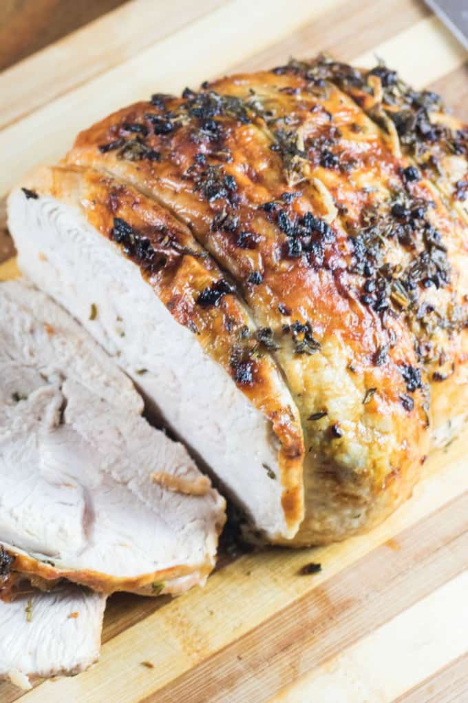 Herbed Butter Roast Turkey Breast sliced on a cutting board