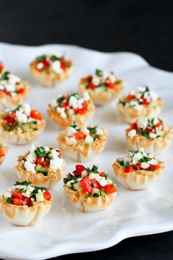 Mini hummus & roasted red pepper phyllo bite on a white serving platter