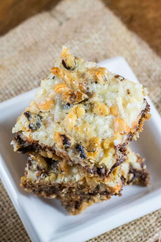 One Pan Magic Cookie Bars stacked on small white dishes