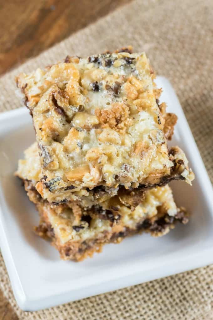 One Pan Magic Cookie Bars stacked on small white dishes