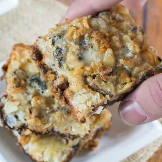 One Pan Magic Cookie Bars being picked up