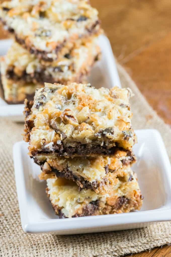 One Pan Magic Cookie Bars stacked on small white dishes