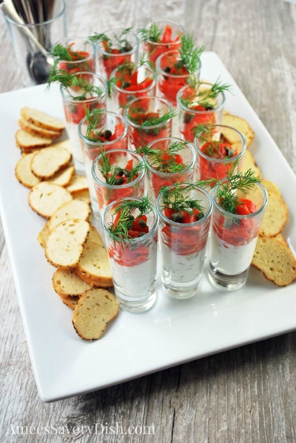 Smoked salmon shooters on a white serving tray with mini toasts