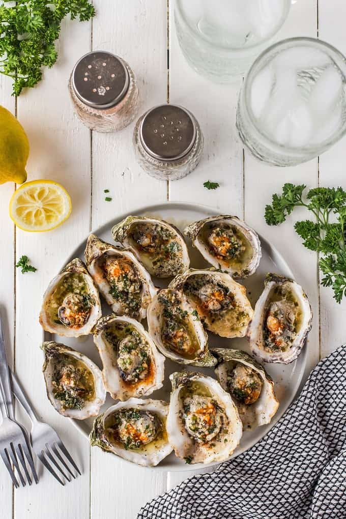 Garlic Herb Butter Grilled Oysters on the half shell on a white serving platter