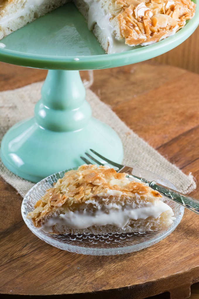 Bee Sting Cake sliced on a cake stand. and a a single serving plated with a fork. 