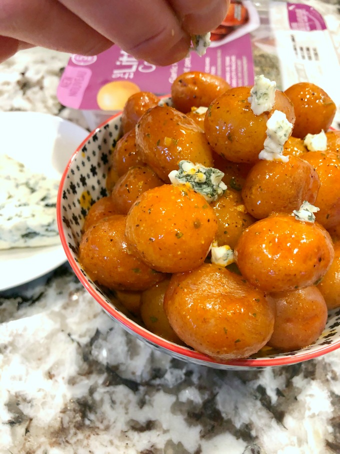 Crumbling blue cheese over Buffalo Wing Potatoes.