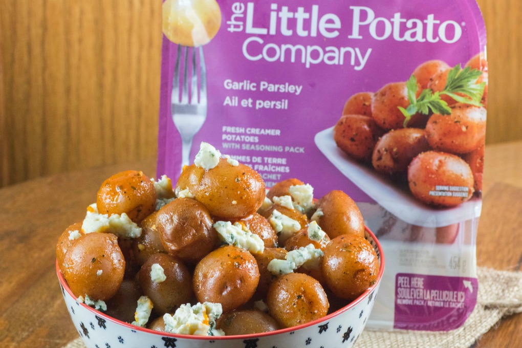 Buffalo Wing Potatoes in a bowl with The Little Potato Company Microwave Ready package. 
