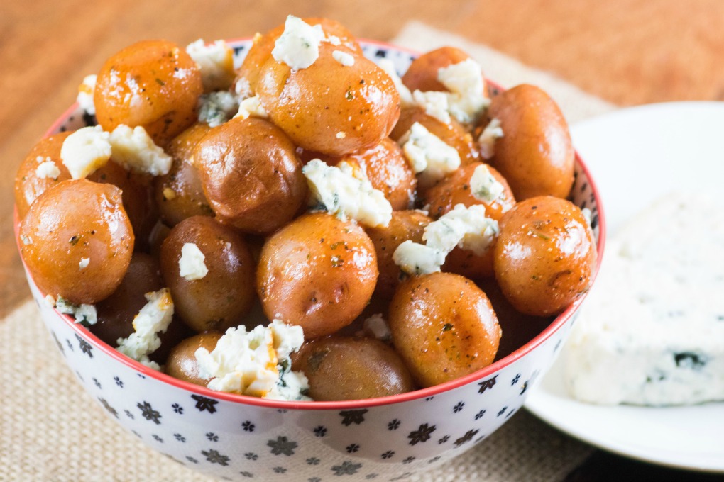 Buffalo Wing Potatoes in a bowl with blue cheese on a plate. 
