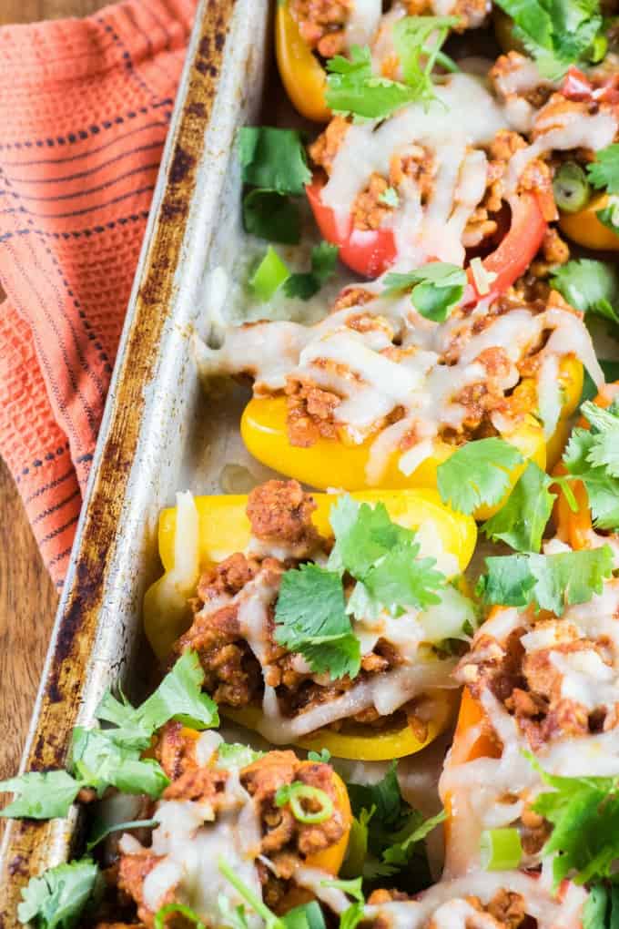 Healthy Mini Pepper Nachos on a baking sheet with an orange tea towel