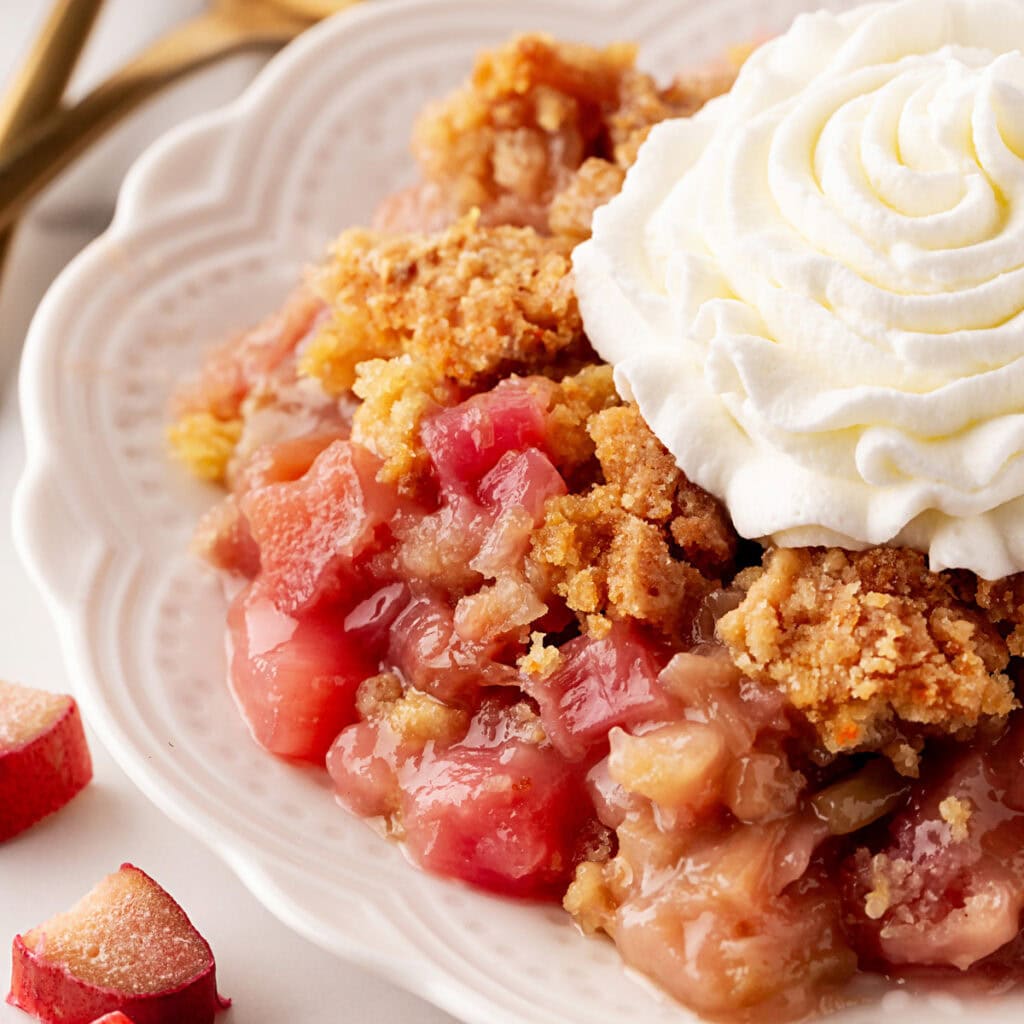 Rhubarb Dump Cake on a plate with whipped cream. 