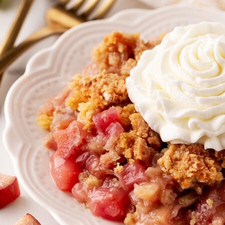 Rhubarb Dump Cake on a plate with whipped cream.