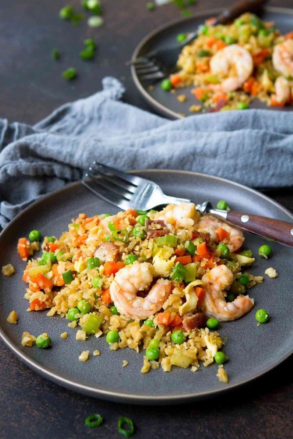 Shrimp Cauliflower Fried Rice Recipe on a black plate with a fork