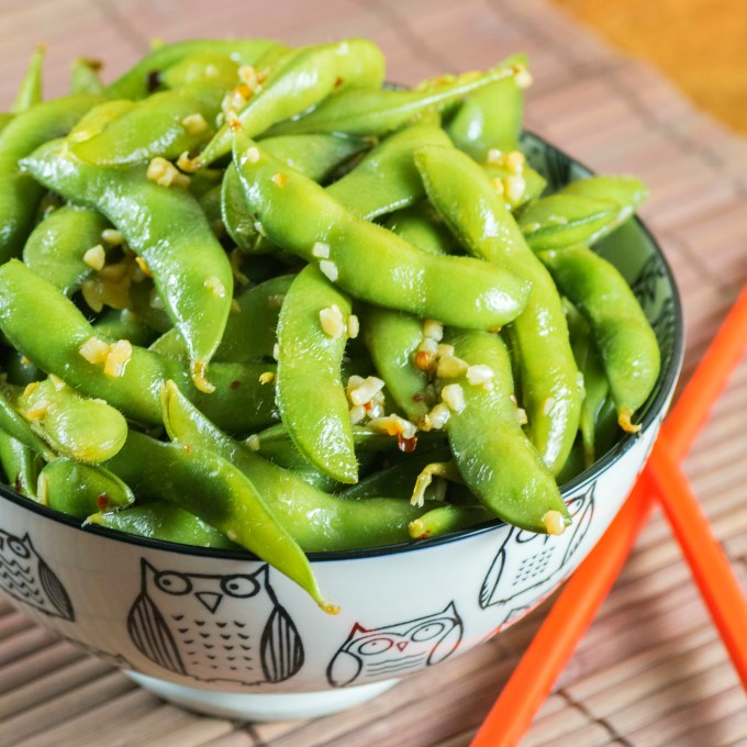 Spicy Edamane in a bowl with red chop sticks