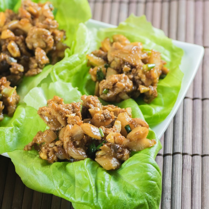 Chicken Lettuce Wraps on a platter on a brown placemat.