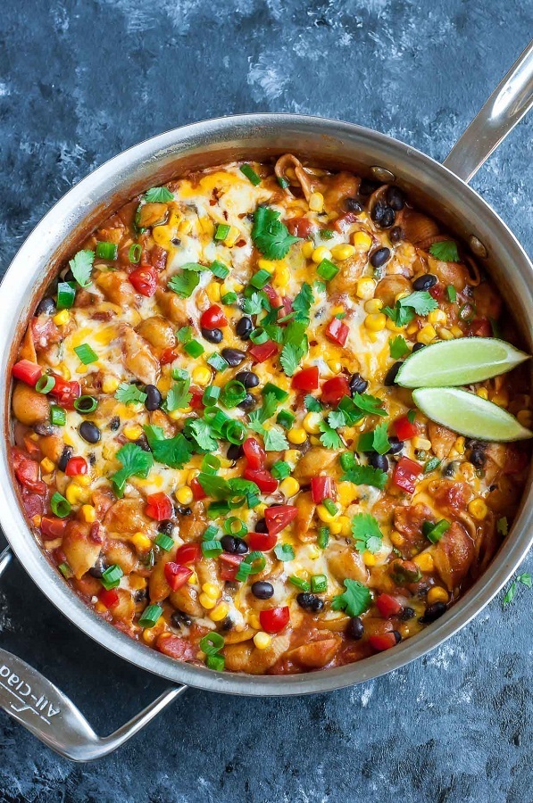 Healthy One Pot Enchilada Pasta in a skillet with lime wedge
