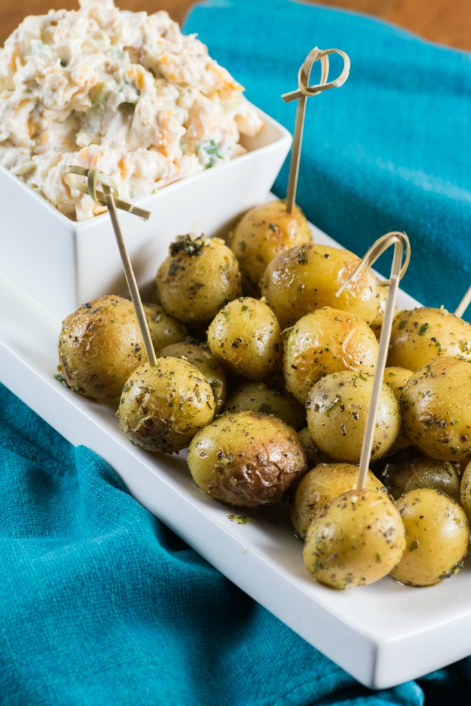 Million Dollar Dip with Roasted Little Potatoes on a white platter with teal napkins