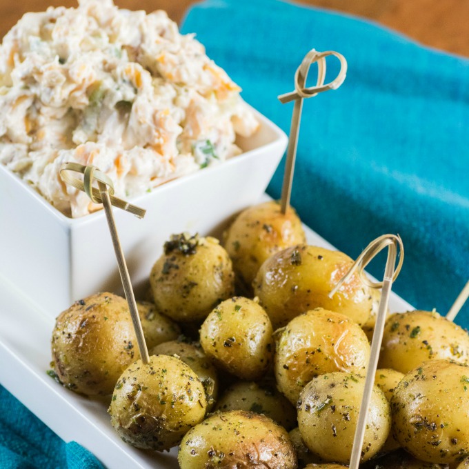 Million Dollar Dip with Roasted Little Potatoes on a white platter with teal napkins