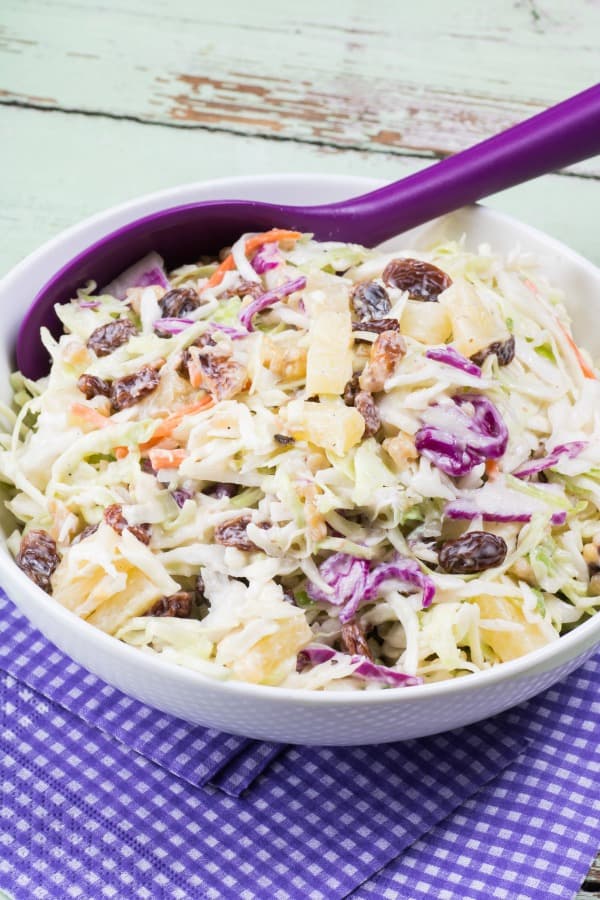 40 Amazing Easter Side Dishes, Pineapple Walnut Raisin Coleslaw in a bowl with a serving spoon