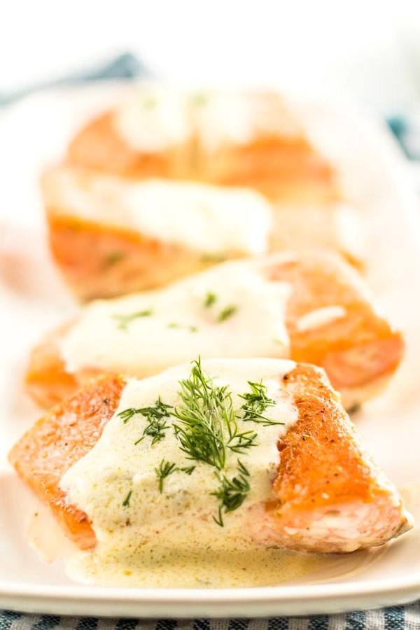 Salmon with Creamy Lemon Dill Sauce (Keto) on a white platter