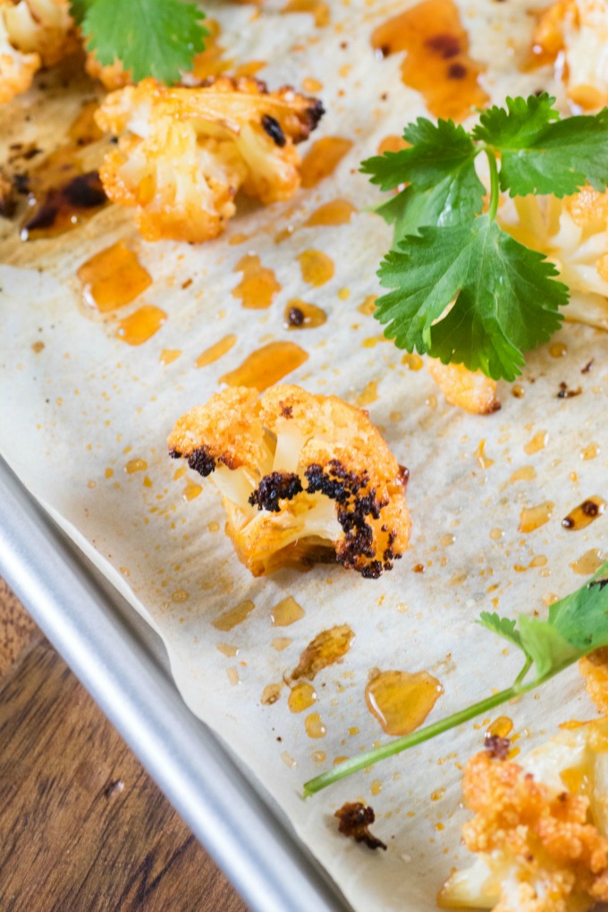 Sweet Sriracha Roasted Cauliflower on parchment paper with cilantro