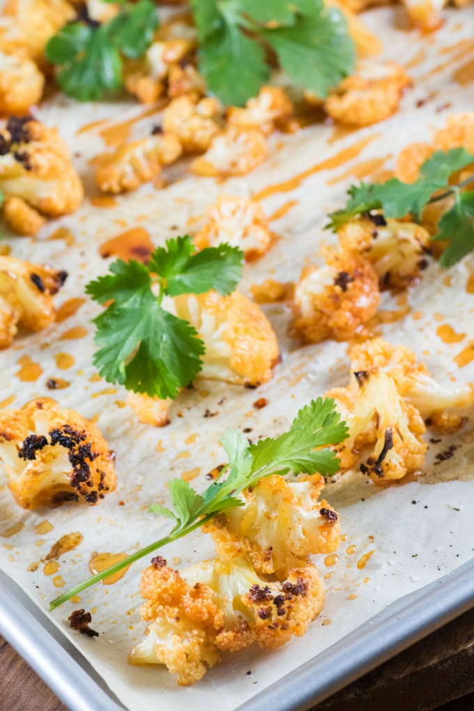 Sweet Sriracha Roasted Cauliflower on parchement on a baking sheet