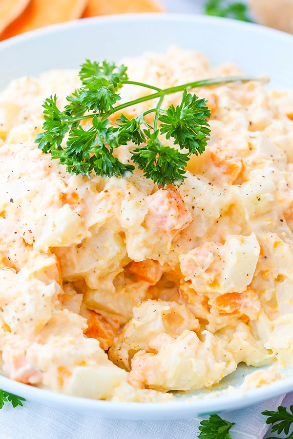 Three potato salad in a white serving bowl