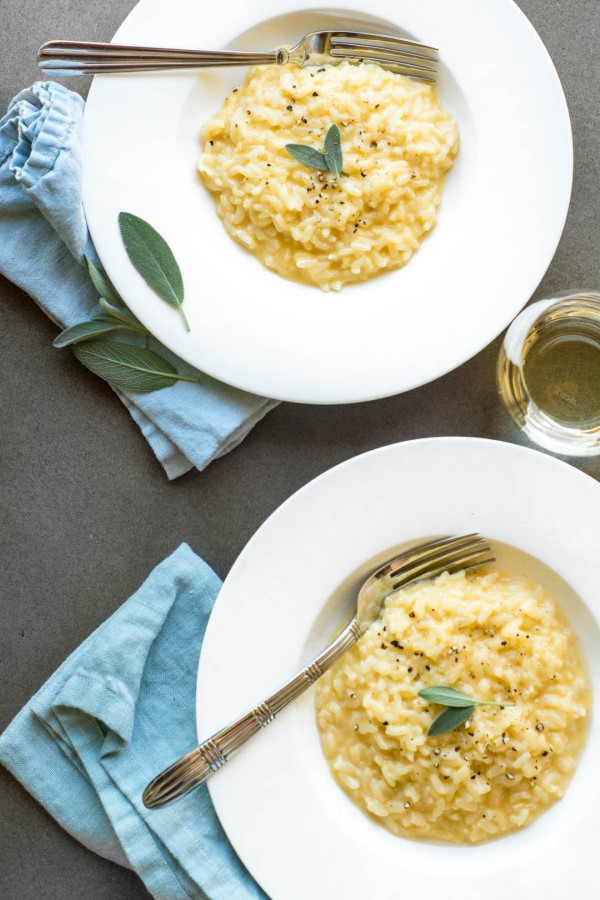 Instant Pot Cheddar Risotto with Fresh Sage in white bowls with forks