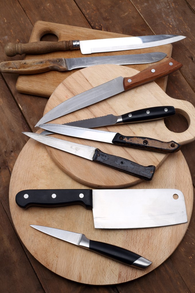 An assortment of kitchen knives on cutting boards.