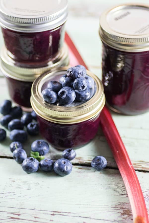 Blueberry Rhubarb Jam in jars with fresh blueberries and rhubarb