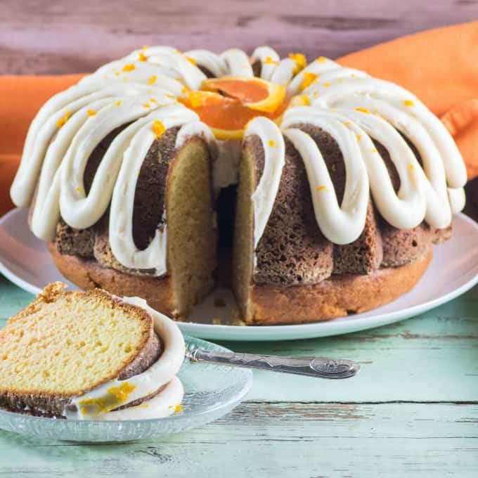 Creamsicle Orange Bundt Cake on a white plate with a slice served