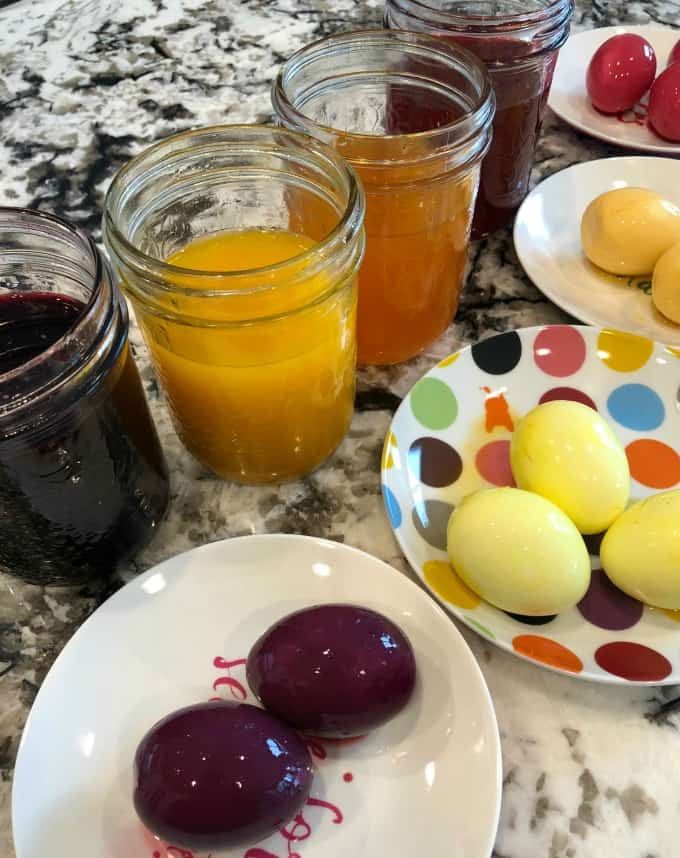 Jars of dye and dyed eggs on plates