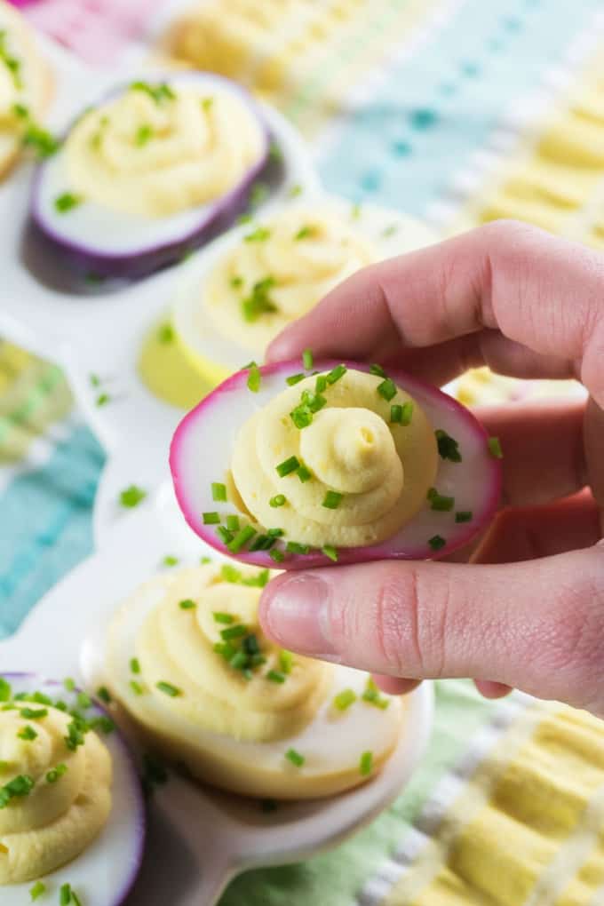 Holding up a pink dyed deviled egg