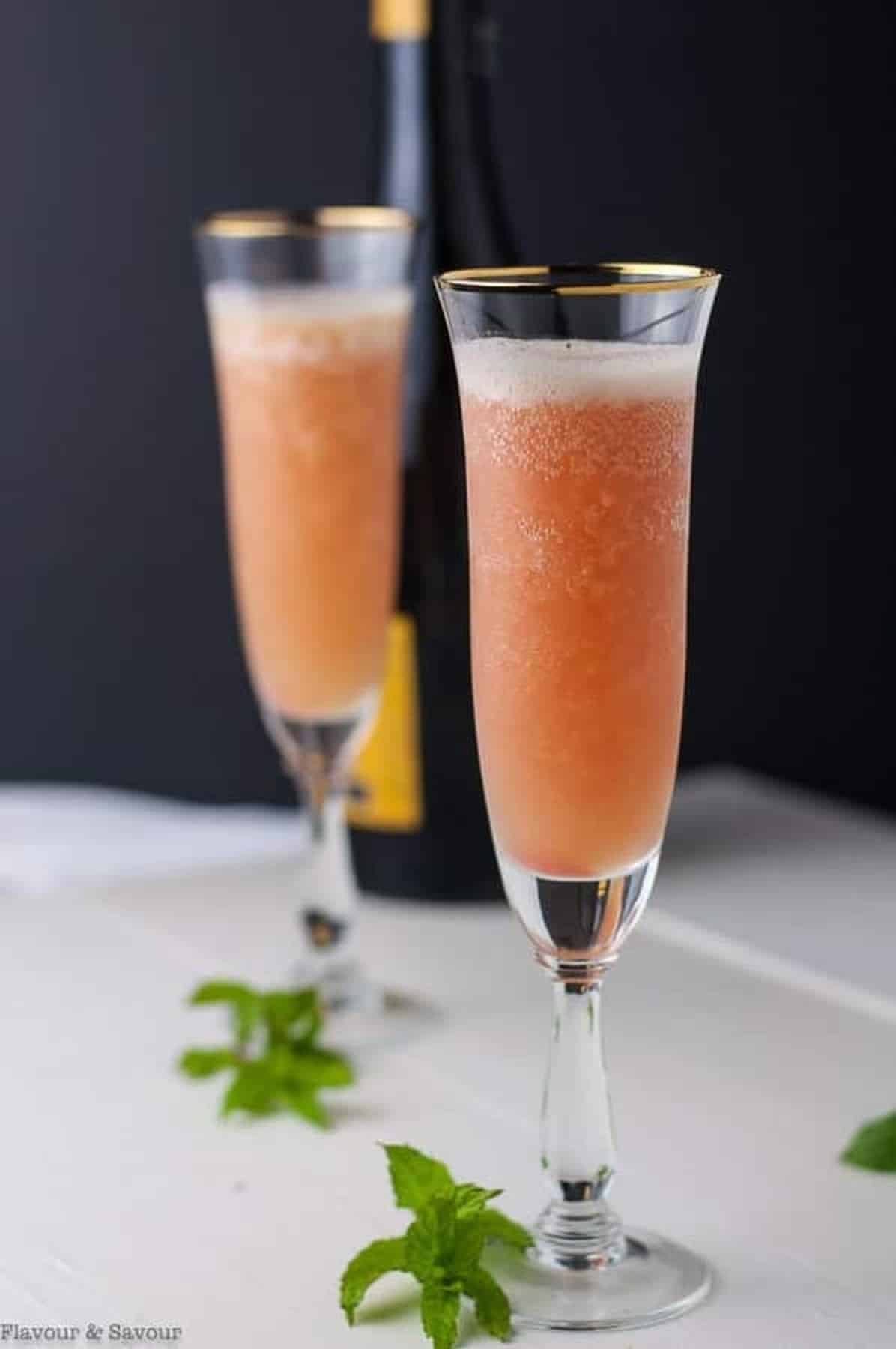 Rhubarb Bellini with Prosecco served in champagne glasses.