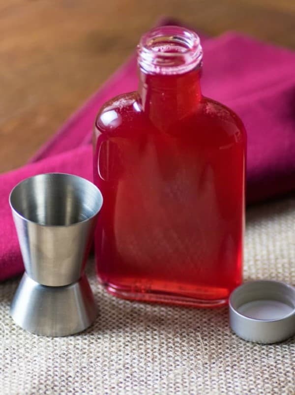 Rhubarb Syrup in a bottle withe a shot glass