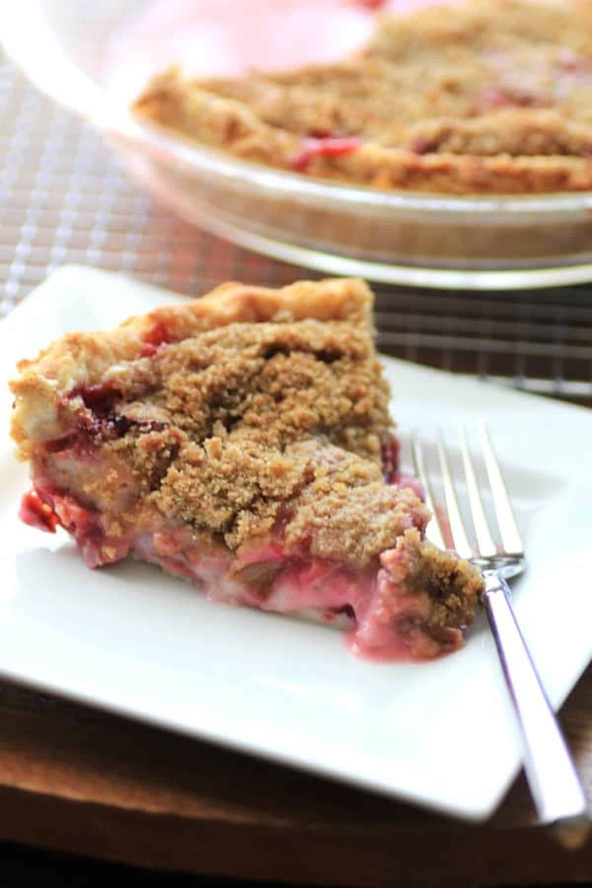 Rhubarb Strawberry Sour Cream Pie served on a white plate with fork.