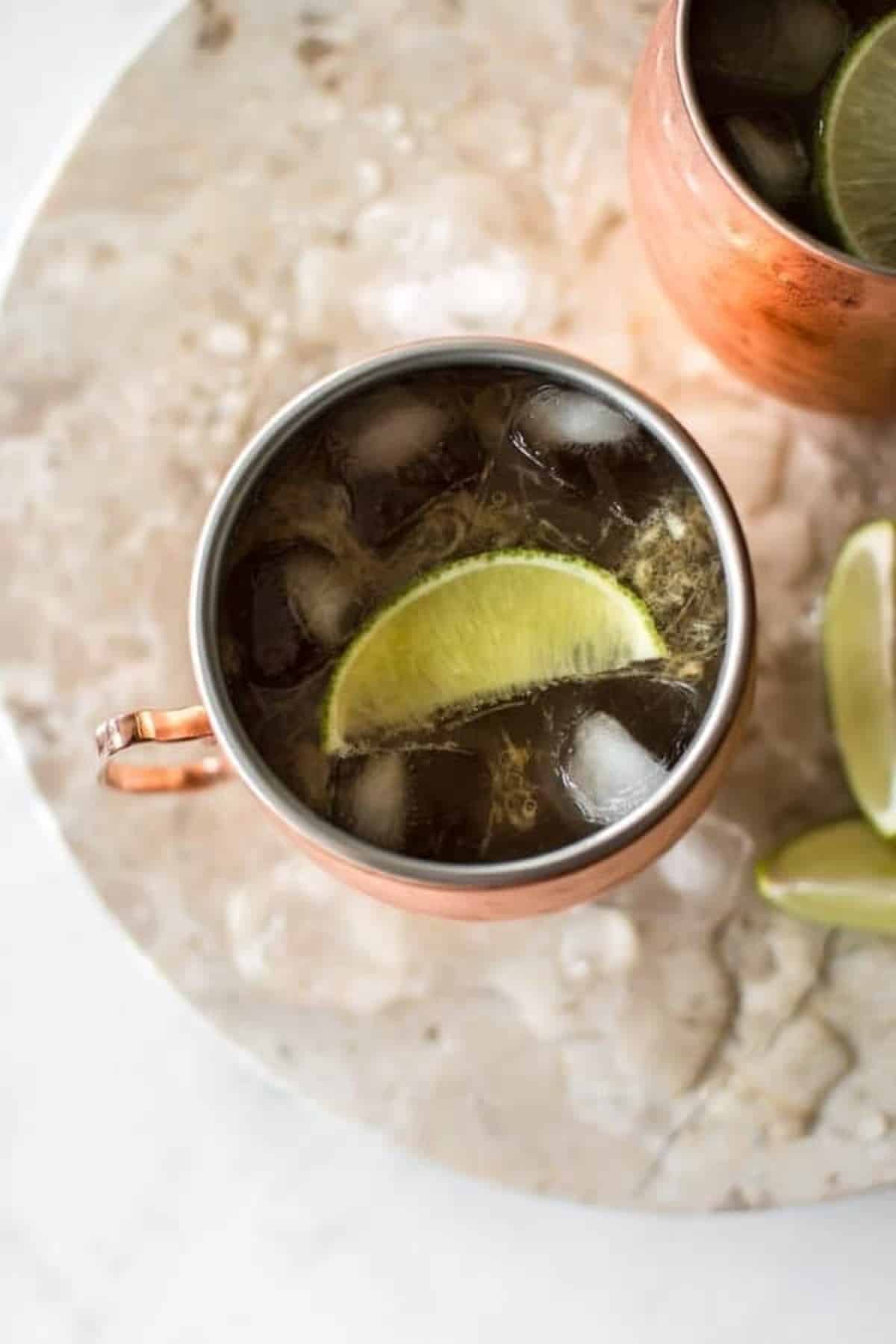 Rhubarb moscow mule served in a copper moscow mule cup with lime.