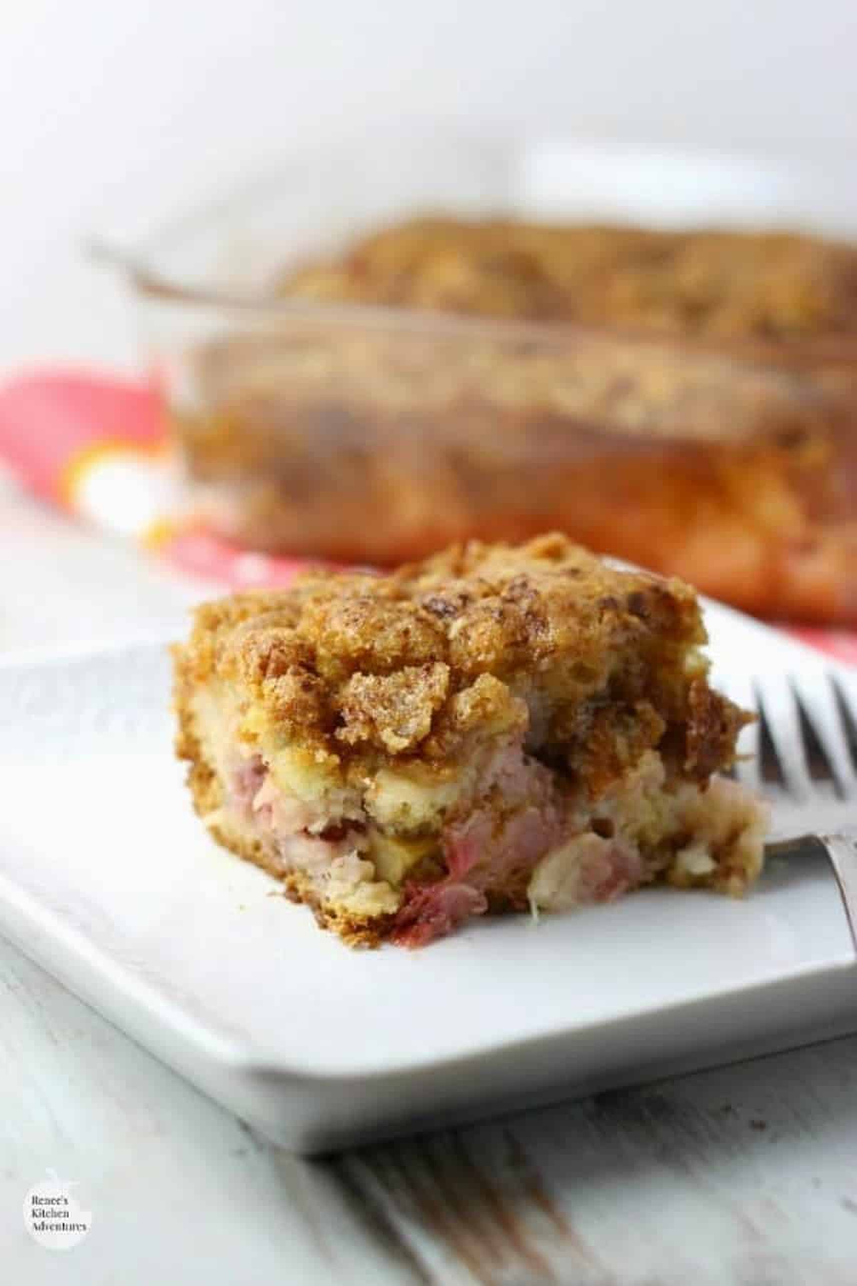 Strawberry Rhubarb Crunch Cake served on a white plate with fork.