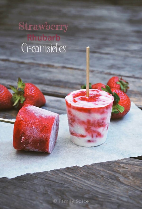 Strawberry Rhubarb Creamsicles on parchment with fresh strawberries 