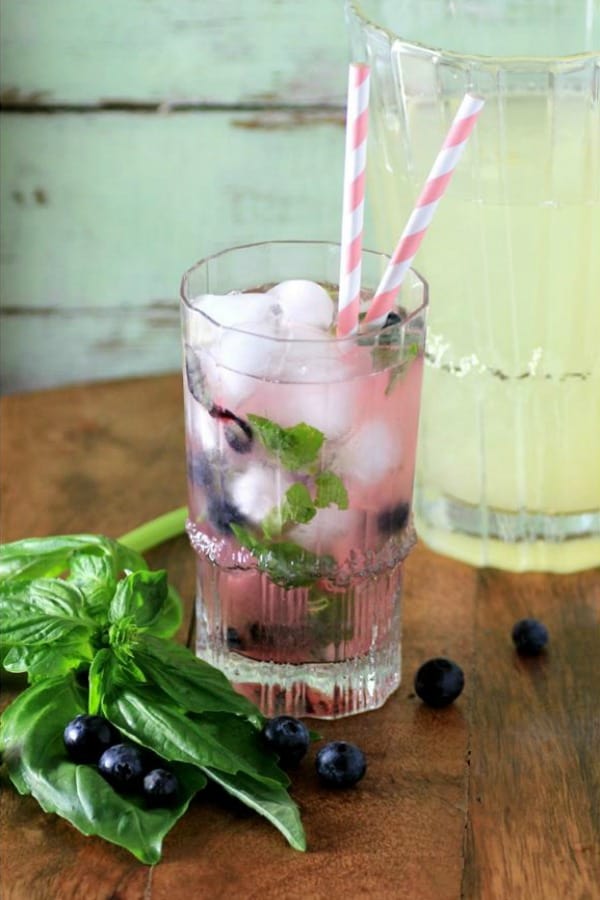 Blueberry Basil Lemonade in a glass with pink and white straws