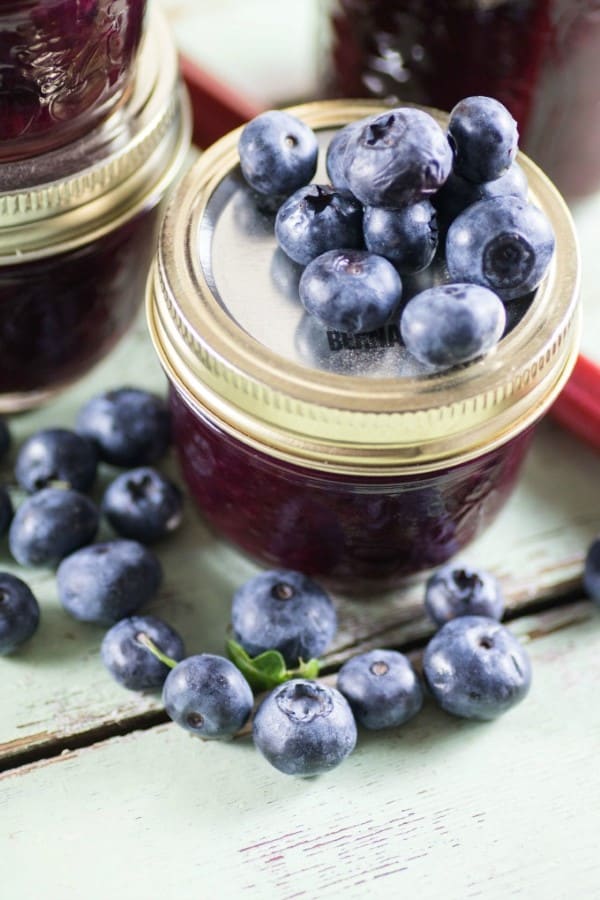 Blueberry Rhubarb Jam in a jar with blueberries on top