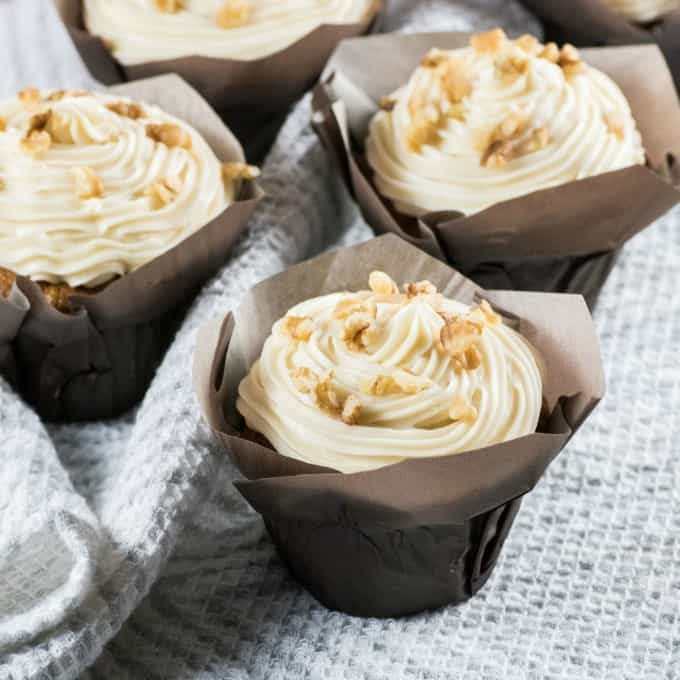 Carrot Cake Cupcakes on a grey and white tea towel. 