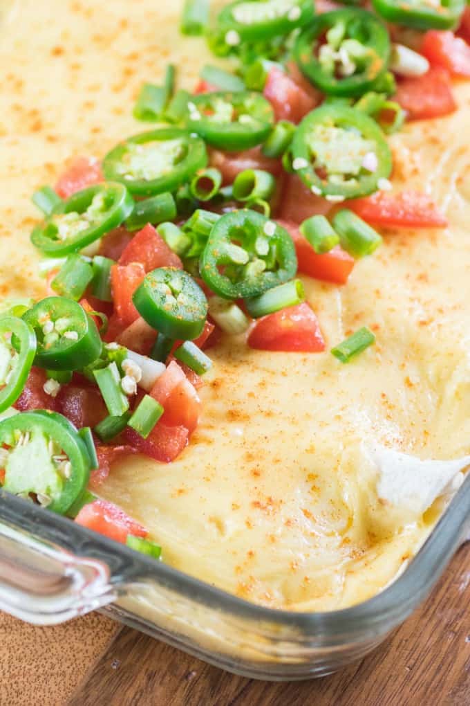 Cheesy Ground Turkey Enchiladas in a casserole dish with jalapeno tomato topping