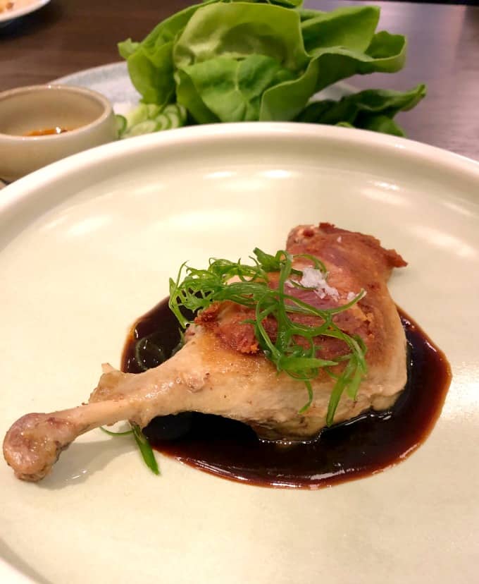 Whole leg duck confit on a plate in hoisin sauce