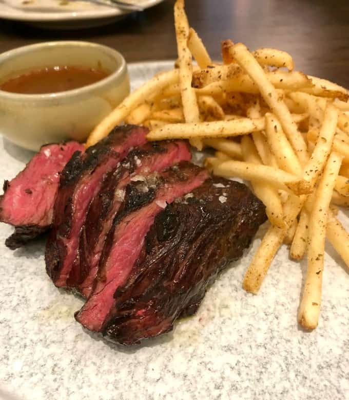 Hanger Steak served with Sauce Au Poivre and perfectly seasoned crispy Frites