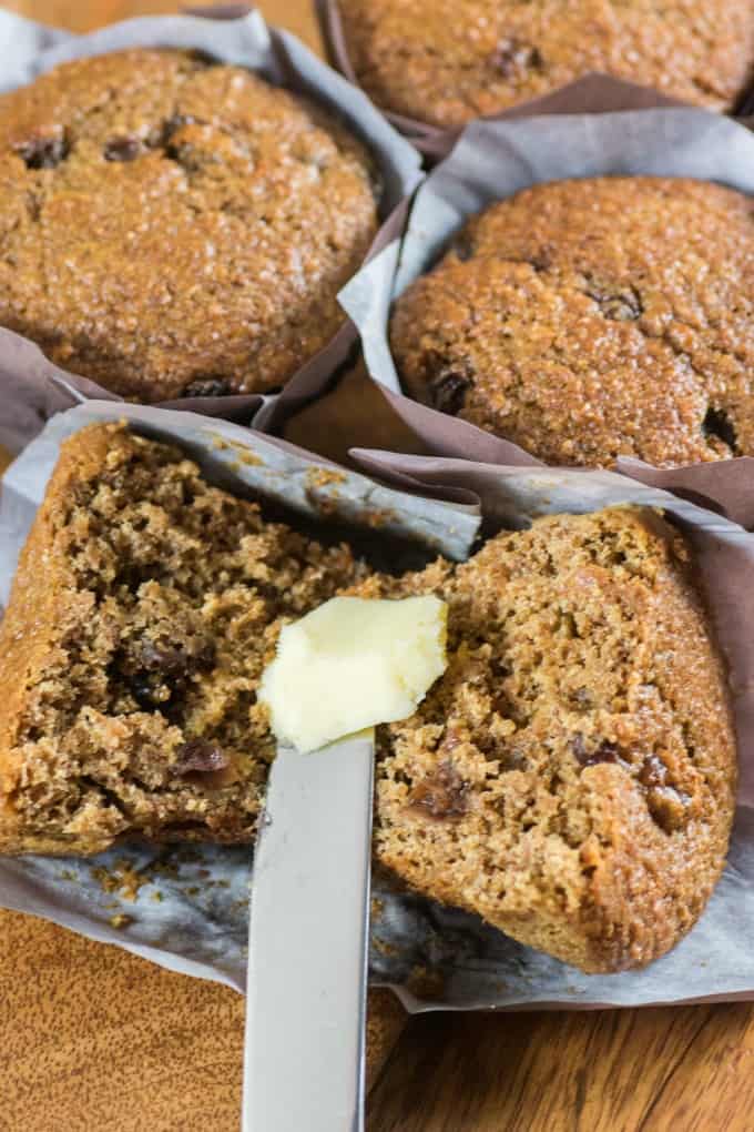 Cutting open a bran muffin and buttering