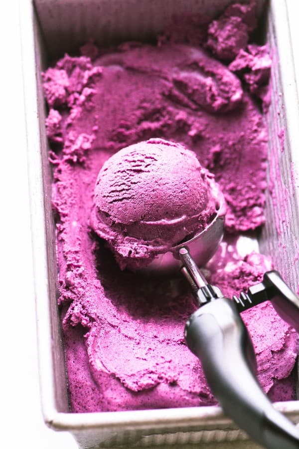 No Churn Wild Blueberry Frozen Yogurt being scooped out of a container