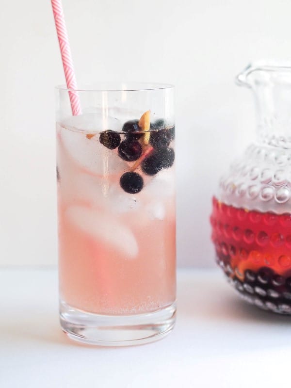 Blueberry Kombucha Sangria in a tall glass with a straw