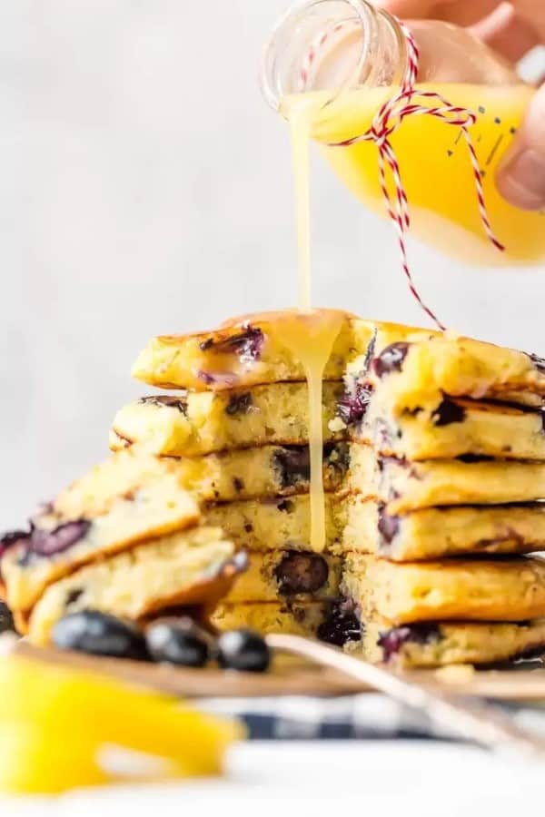 Blueberry Pancakes with Lemon Sauce being poured on