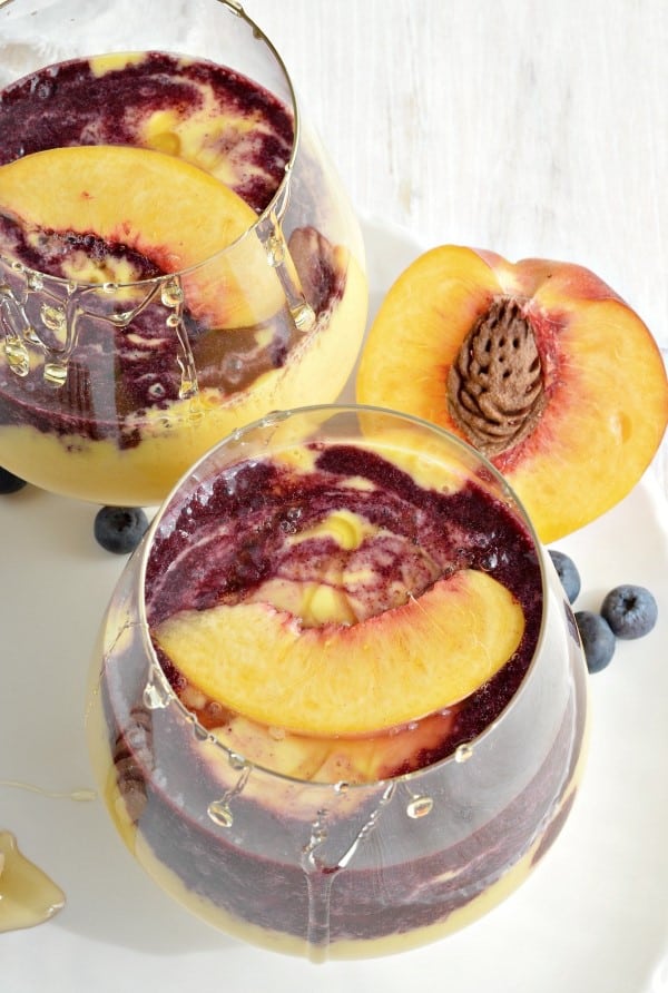 Peach Smoothies with Wild Blueberry Swirl in glasses on a white plate